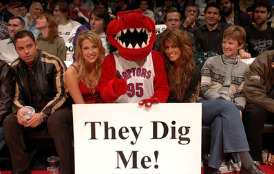 Miriam McDonald & Shenae Grimes with The Raptor – “They Dig Me!”
Miriam McDonald (Emma Nelson) and Shenae Grimes (Darcy Edwards) pose courtside with The Raptor during the Utah Jazz vs. Toronto Raptors game on November 11, 2005, at the Air Canada Centre in Toronto, Ontario, Canada. The Raptor holds a sign reading, “They Dig Me!”
Keywords: Miriam McDonald;Shenae Grimes;Degrassi;Degrassi: The Next Generation;Emma Nelson;Darcy Edwards;The Raptor;Toronto Raptors;Utah Jazz;NBA;basketball;Air Canada Centre;Toronto;Ontario;Canada;2005;courtside;mascot;They Dig Me