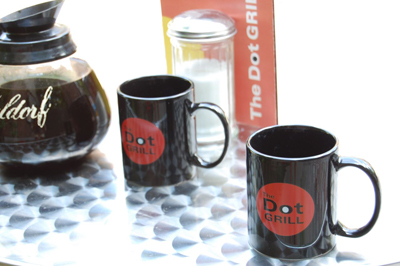 The Dot Mug – Promotional Photo (2007)
Promotional photo showcasing The Dot Mug as styled in a classic diner setup, complete with a Dot Grill menu and coffee pot. Part of the official Degrassi Online Store release in 2007.
Keywords: The Dot Grill;Degrassi mug;promo photo;coffee;official merch;diner scene;2007;Bruzer;props
